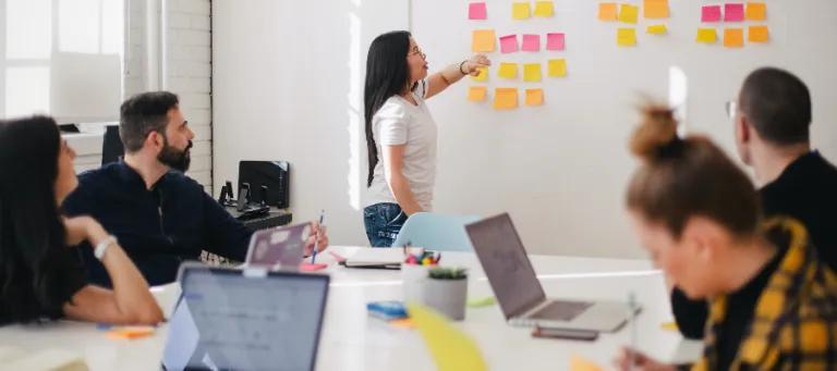 A meeting with people, presenting with a whiteboard